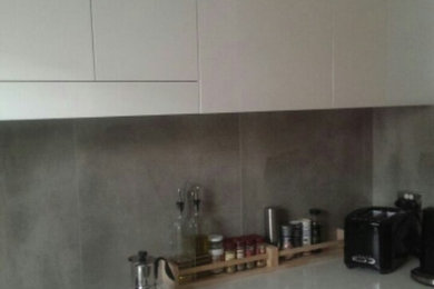 Small kitchen in Sydney with grey splashback and porcelain splashback.
