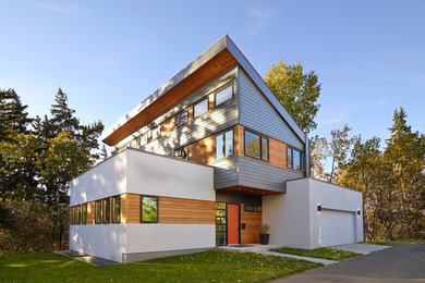 This is an example of a mid-sized contemporary two-storey exterior in Edmonton with mixed siding.