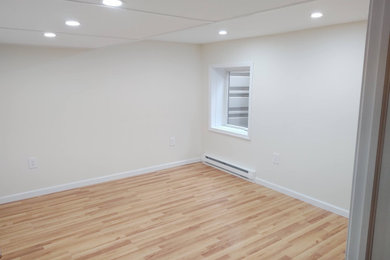 Mid-sized guest laminate floor and beige floor bedroom photo in New York with beige walls