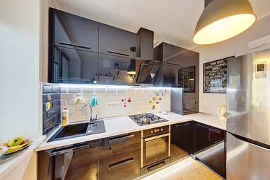 На фото: маленькая отдельная, угловая кухня в современном стиле с стеклянными фасадами, черными фасадами и фартуком из плитки кабанчик для на участке и в саду