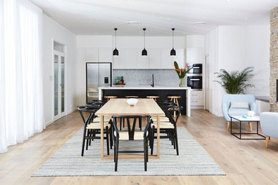 Photo of a contemporary kitchen/dining combo in Sydney with light hardwood floors.