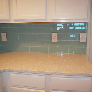 Mid-sized beach style kitchen pantry designs - Kitchen pantry - mid-sized beach style u-shaped porcelain floor kitchen pantry idea in Orlando with a double-bowl sink, shaker cabinets, white cabinets, quartz countertops, blue backsplash, glass tile backsplash, white appliances and a peninsula