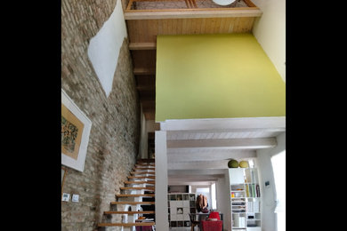 Ispirazione per un grande soggiorno contemporaneo aperto con pareti verdi, pavimento con piastrelle in ceramica, pavimento grigio e pareti in mattoni
