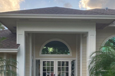 Large contemporary beige one-story concrete fiberboard exterior home idea in Other with a shingle roof