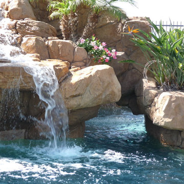Rock Swimming Pool with Slide, Waterfall and a Table in the pool.