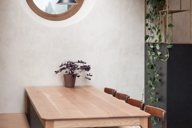 This is an example of a medium sized modern kitchen/dining room in London with beige walls, concrete flooring, no fireplace, grey floors and brick walls.