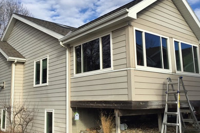 Mid-sized beige one-story wood exterior home idea in Other