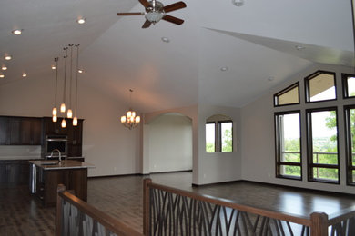 Example of a mid-sized minimalist open concept medium tone wood floor and brown floor living room design in Other with beige walls and no fireplace