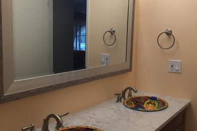 Example of a mid-sized classic 3/4 beige tile and porcelain tile ceramic tile alcove shower design in Phoenix with shaker cabinets, light wood cabinets, a two-piece toilet, beige walls, a drop-in sink and tile countertops