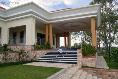Example of a large classic beige one-story brick exterior home design in Other with a tile roof