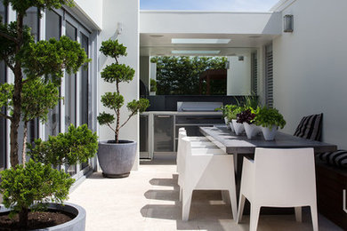 Inspiration for a small contemporary courtyard patio in Sydney with natural stone pavers and no cover.