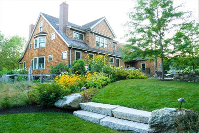 This is an example of a large coastal shade backyard stone landscaping in Boston for spring.