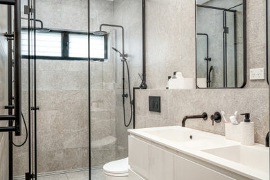 Large modern kids bathroom in Sydney with flat-panel cabinets, white cabinets, an alcove tub, a corner shower, a one-piece toilet, beige tile, porcelain tile, beige walls, porcelain floors, an integrated sink, engineered quartz benchtops, beige floor, an open shower, white benchtops, a niche, a single vanity and a floating vanity.