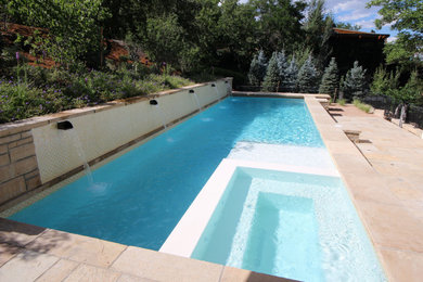 Design ideas for a large modern backyard rectangular pool in Denver with natural stone pavers.