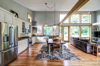 Eat-in kitchen - large transitional l-shaped light wood floor eat-in kitchen idea in Other with shaker cabinets, white cabinets, no island, a farmhouse sink, concrete countertops and stainless steel appliances