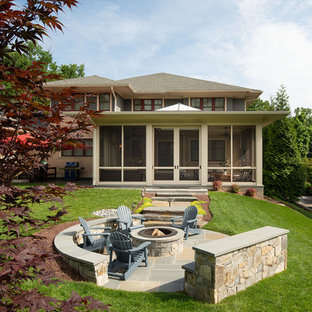 Photo of a large transitional backyard full sun formal garden for fall in DC Metro with with fireplace and natural stone pavers.
