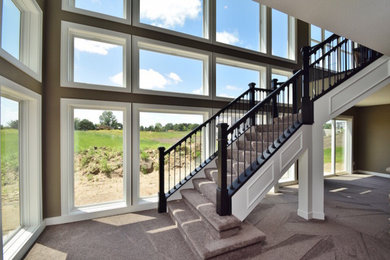 Carpeted curved staircase photo in Minneapolis with carpeted risers