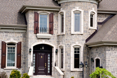 Mid-sized victorian gray two-story stone house exterior idea in Toronto with a hip roof and a shingle roof