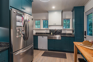 Small country galley eat-in kitchen in Other with an undermount sink, shaker cabinets, green cabinets, soapstone benchtops, black splashback, light hardwood floors, no island, beige floor, black benchtop and wood.