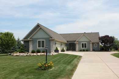 This is an example of a mid-sized traditional one-storey blue exterior in Milwaukee with a gable roof and wood siding.