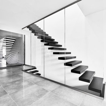 Kragarmtreppe in matt schwarz mit Weißglas