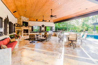 Elegant backyard patio photo in Houston with a fireplace and a gazebo
