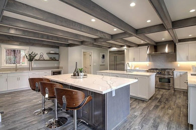 This is an example of a large contemporary u-shaped eat-in kitchen in San Francisco with a single-bowl sink, recessed-panel cabinets, white cabinets, quartzite benchtops, white splashback, mosaic tile splashback, stainless steel appliances, light hardwood floors, no island, grey floor and white benchtop.