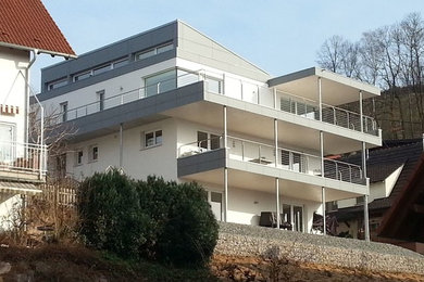 Large contemporary three-storey stucco white exterior in Frankfurt with a shed roof.