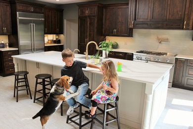 Inspiration for a large l-shaped ceramic tile and gray floor open concept kitchen remodel in Other with an undermount sink, flat-panel cabinets, gray cabinets, quartz countertops, gray backsplash, glass tile backsplash, stainless steel appliances, an island and white countertops