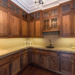 Mittelgroße Klassische Küche ohne Insel in L-Form mit Einbauwaschbecken, Vorratsschrank, Kassettenfronten, Glas-Arbeitsplatte und dunklem Holzboden in New York