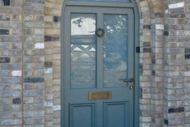 他の地域にある高級な中くらいなおしゃれな玄関ドア (グレーのドア) の写真