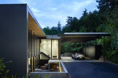 Inspiration for a mid-sized modern split-level black exterior in Seattle with metal siding and a flat roof.