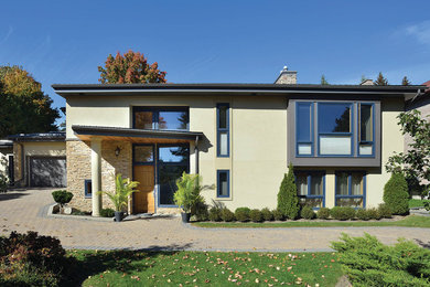 Mid-sized contemporary beige two-story stucco exterior home idea in Toronto with a metal roof