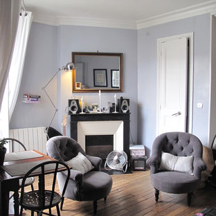 Ispirazione per un piccolo soggiorno chic chiuso con pavimento in legno massello medio, camino classico, cornice del camino in pietra, nessuna TV e pareti viola