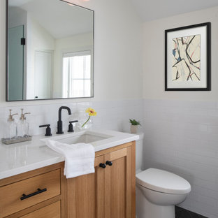Esempio di una piccola stanza da bagno padronale chic con ante lisce, ante in legno scuro, piastrelle bianche, piastrelle in ceramica, pareti bianche, pavimento con piastrelle in ceramica, lavabo sottopiano, top in superficie solida, pavimento nero, top bianco, un lavabo, mobile bagno freestanding e boiserie