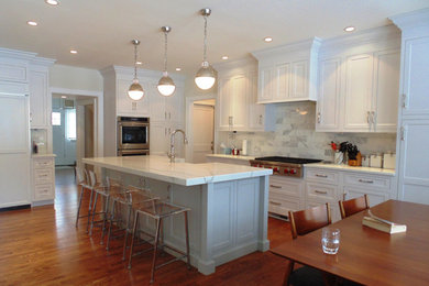 Inspiration for a large timeless l-shaped medium tone wood floor and brown floor eat-in kitchen remodel in New York with recessed-panel cabinets, white cabinets, quartz countertops, gray backsplash, stone tile backsplash, stainless steel appliances and an island