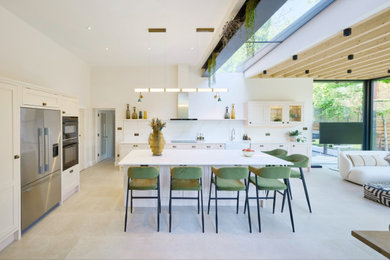 Inspiration for a medium sized modern grey and pink single-wall open plan kitchen in London with a single-bowl sink, raised-panel cabinets, pink cabinets, marble worktops, white splashback, marble splashback, black appliances, ceramic flooring, an island, white floors, white worktops and a timber clad ceiling.