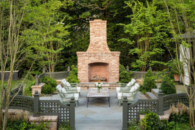 Example of a mid-sized classic backyard patio design in New York with a fireplace