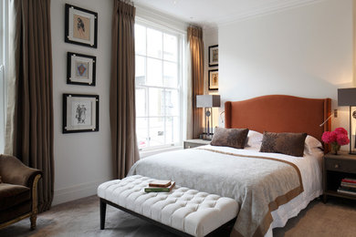 Photo of a traditional master bedroom in London with white walls and carpet.
