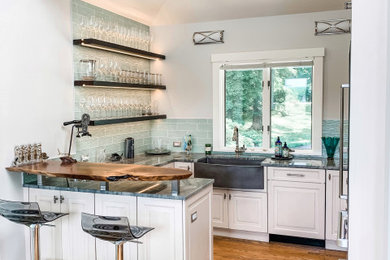 Home bar - mid-sized coastal u-shaped medium tone wood floor and brown floor home bar idea in Baltimore with raised-panel cabinets, white cabinets, granite countertops, blue backsplash and glass tile backsplash