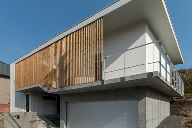 Ejemplo de fachada de casa blanca moderna de tamaño medio de dos plantas con revestimiento de hormigón