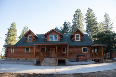 Mountain style brown two-story wood house exterior photo in Los Angeles with a shingle roof