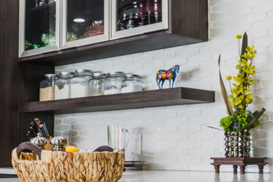 Open concept kitchen - mid-sized traditional u-shaped open concept kitchen idea in Denver with flat-panel cabinets, dark wood cabinets, quartz countertops, white backsplash, glass tile backsplash, an island and white countertops