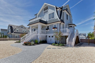 Photo of a large beach style three-storey blue exterior in New York with wood siding and a gambrel roof.