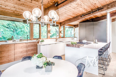 Example of a large 1950s l-shaped light wood floor and brown floor eat-in kitchen design in Detroit with an undermount sink, flat-panel cabinets, white cabinets, quartz countertops, white backsplash, stone slab backsplash, paneled appliances, an island and white countertops