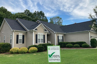 Traditional one-story house exterior idea in Raleigh with a black roof
