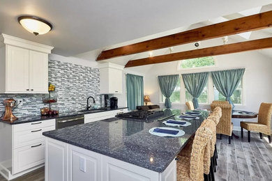 Inspiration for a large coastal ceramic tile, gray floor and vaulted ceiling eat-in kitchen remodel in Los Angeles with an undermount sink, raised-panel cabinets, white cabinets, granite countertops, blue backsplash, mosaic tile backsplash, stainless steel appliances, an island and blue countertops