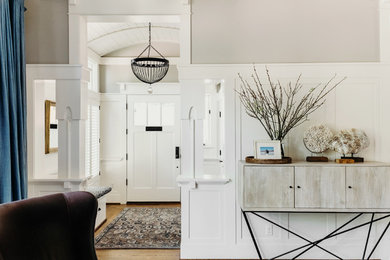 Mid-sized arts and crafts medium tone wood floor and brown floor entryway photo in Portland with beige walls and a white front door