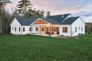 Inspiration for a mid-sized cottage white one-story vinyl and board and batten exterior home remodel in Boston with a shingle roof and a black roof