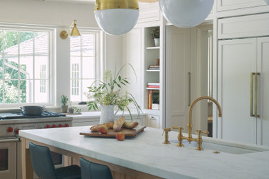 Kitchen - transitional medium tone wood floor and brown floor kitchen idea in Birmingham with recessed-panel cabinets, white cabinets, marble countertops, white appliances, an island, white countertops and an undermount sink